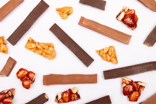 Mélange de morceaux de chocolat et de praliné sur fond blanc, idéal pour une recette gourmande.