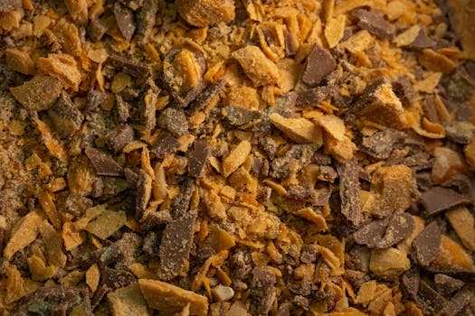 Mélange de morceaux de praliné croustillant et de chocolat, texture dorée et appétissante.